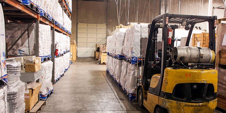 Image of a warehouse forklift transporting freight as part of a supply chain solution.